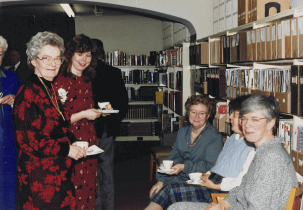 people with teacups surrounded by books